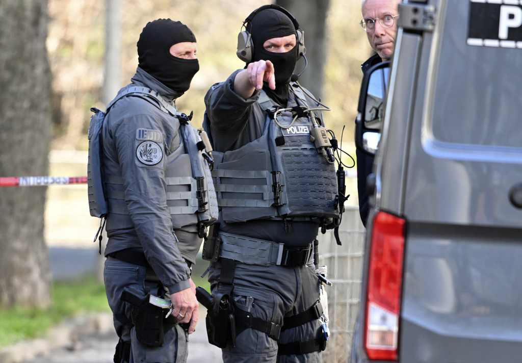 Officers from the police defusing service stand near a damaged vehicle on an access road to the Rhine bridge, in Mannheim, Germany, Monday, March 3, 2025, following an incident when a car rammed into a crowd, German police said. (Photo dpa via AP)