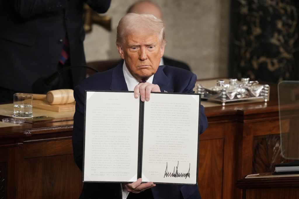 President Donald Trump holds up a signed executive order as he addresses a joint session of Congress at the Capitol in Washington, Tuesday, March 4, 2025. (AP Photo)